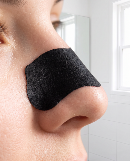 Charcoal nose pore strip applied on nose, clear on-skin shot